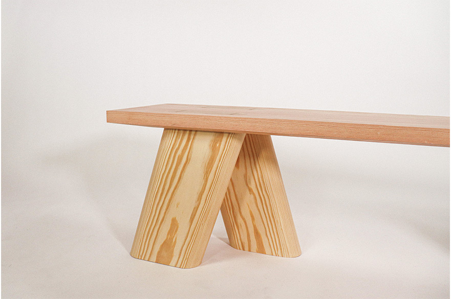 A wooden bench with a pink backgorund