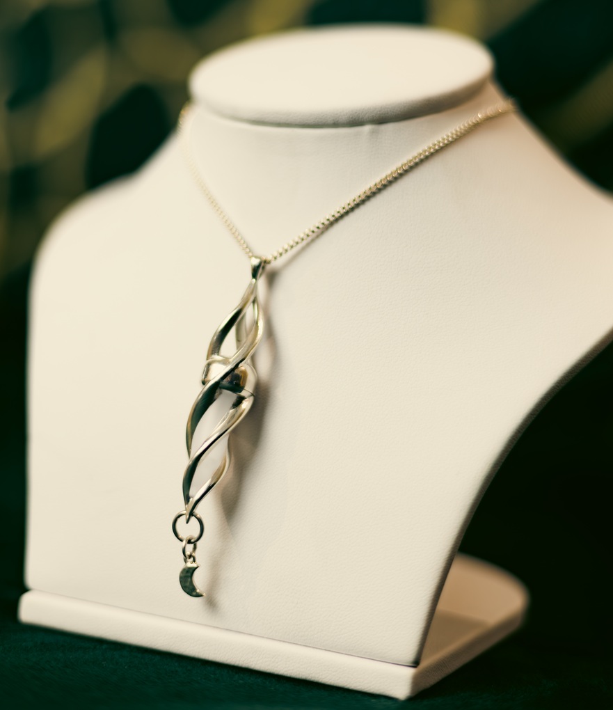 A pendant displayed on a jewellery display stand.