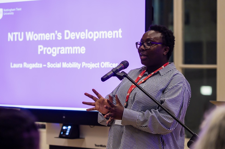 A Social Mobility Project officer presenting at an event in front of a screen