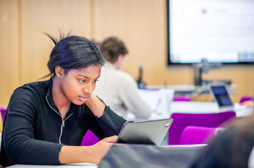 female student working on laptop in seminar