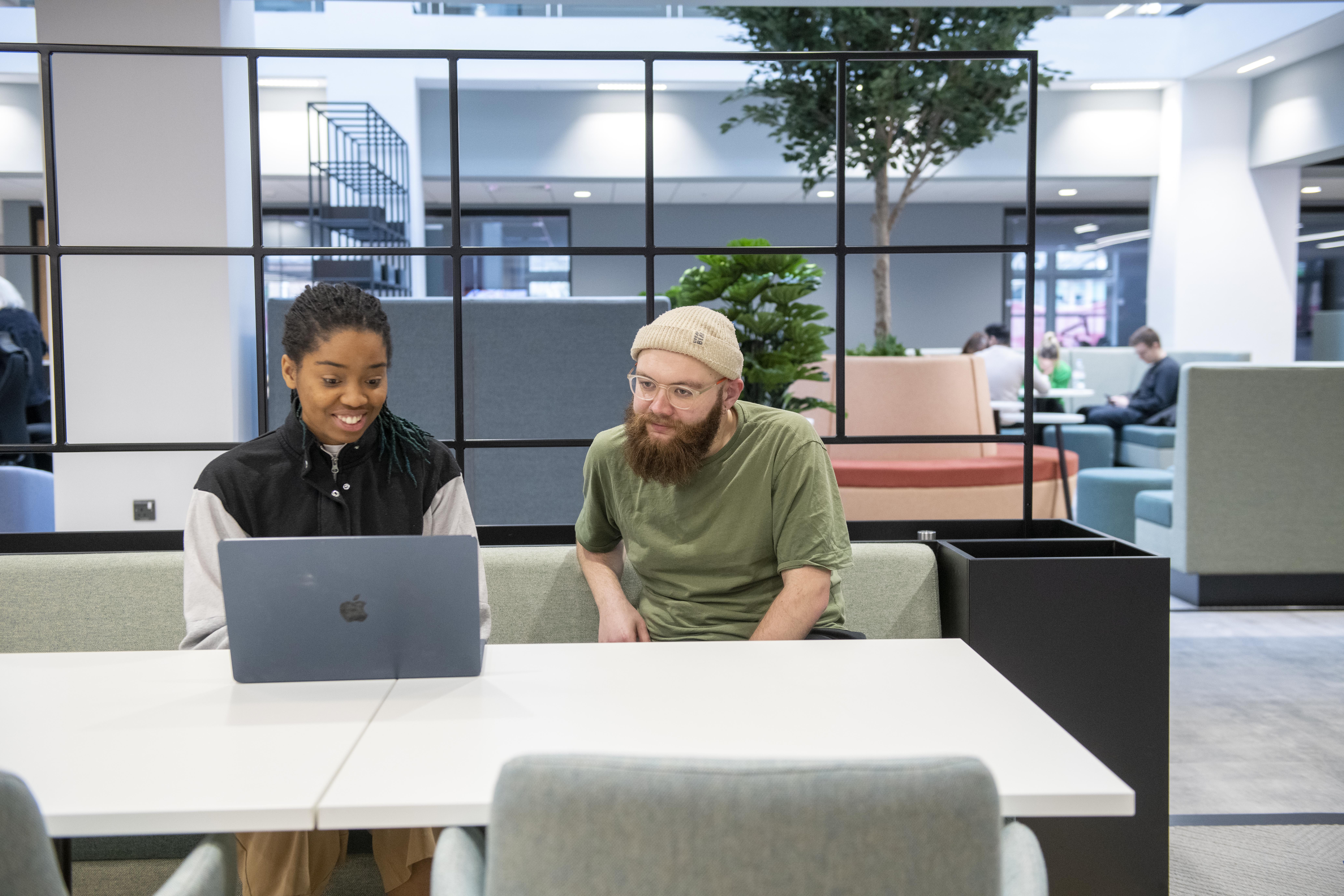 Students working at laptop in Postgraduate Centre