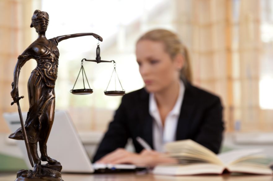 Female Lawyer Looking at Laptop and Books