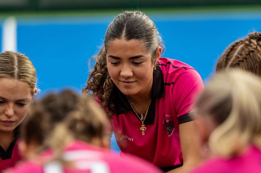a close up of the Women's Hockey first team in a team huddle