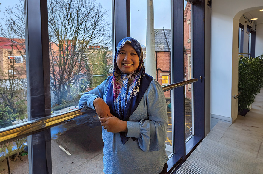 Farah smiling at the camera inside a hallway