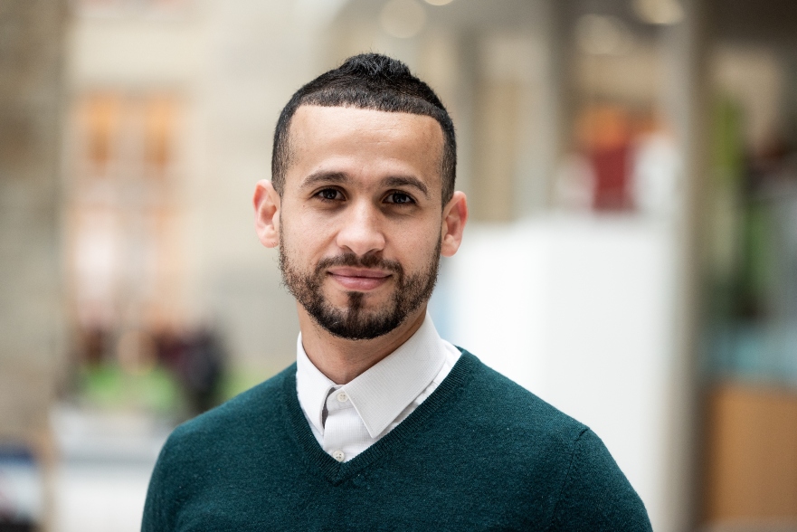 Professional image of person smiling at camera in green jumper