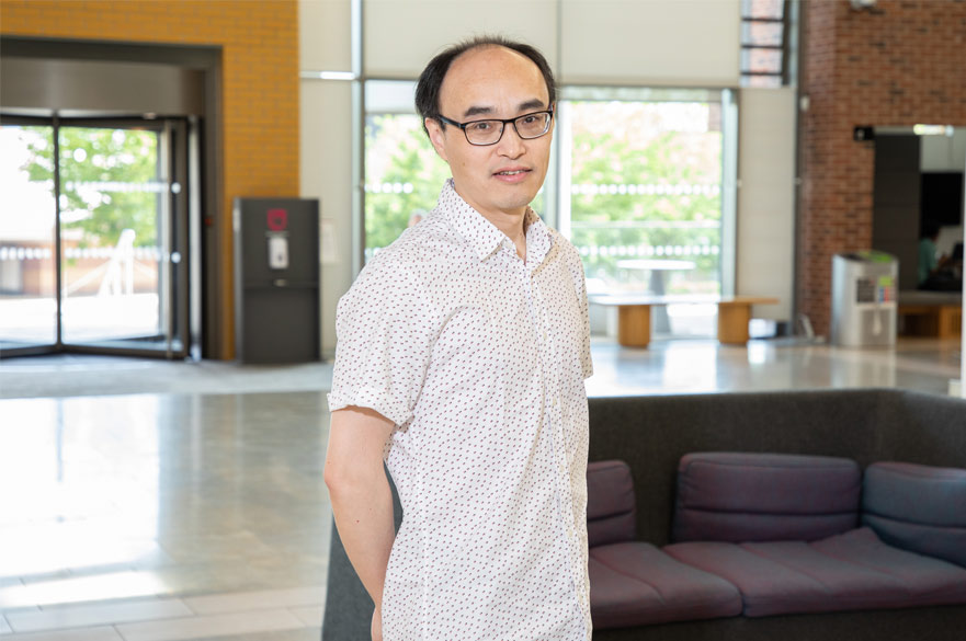Wenbin Zhang in the lobby of the Clifton Pavilion, hands behind his back, looking into the camera.