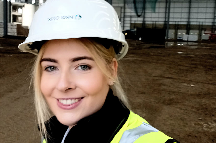Eleanor smiling at the camera wearing a hard hat