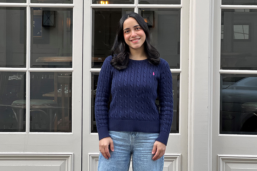 May smiling at the camera in front of a glass door