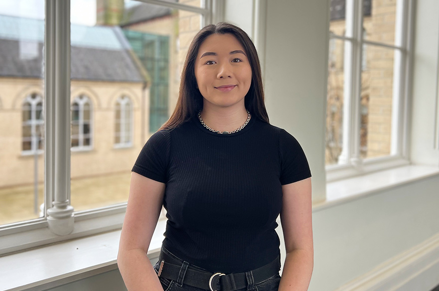 Tai-Li smiling at the camera inside of the Arkwright building at NTU