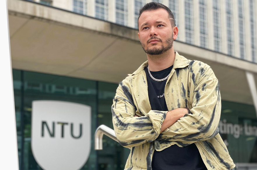 Tim posing for the camera in front of the Newton Building at NTU