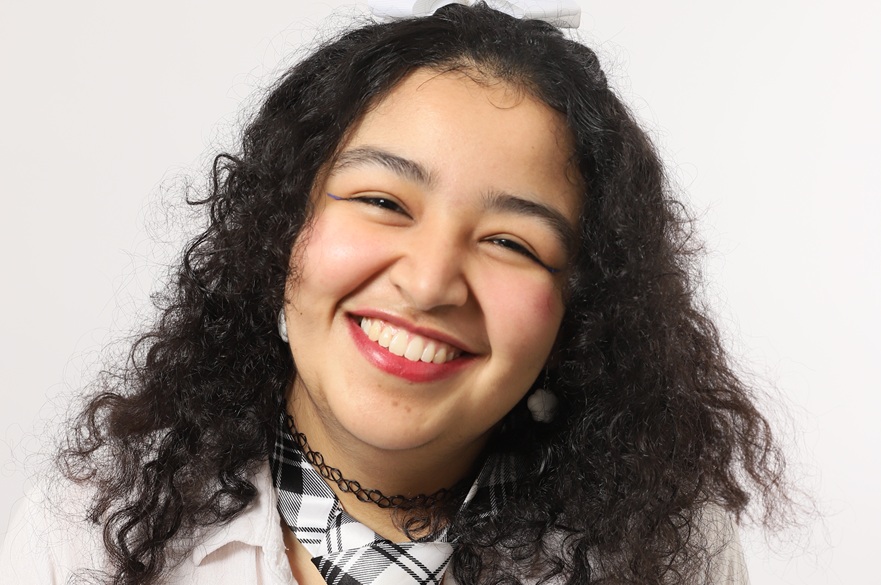 A student looking into the camera, smiling