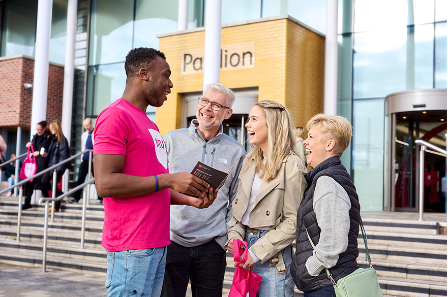 Student ambassador speaking to family at open day outside of Pavillion