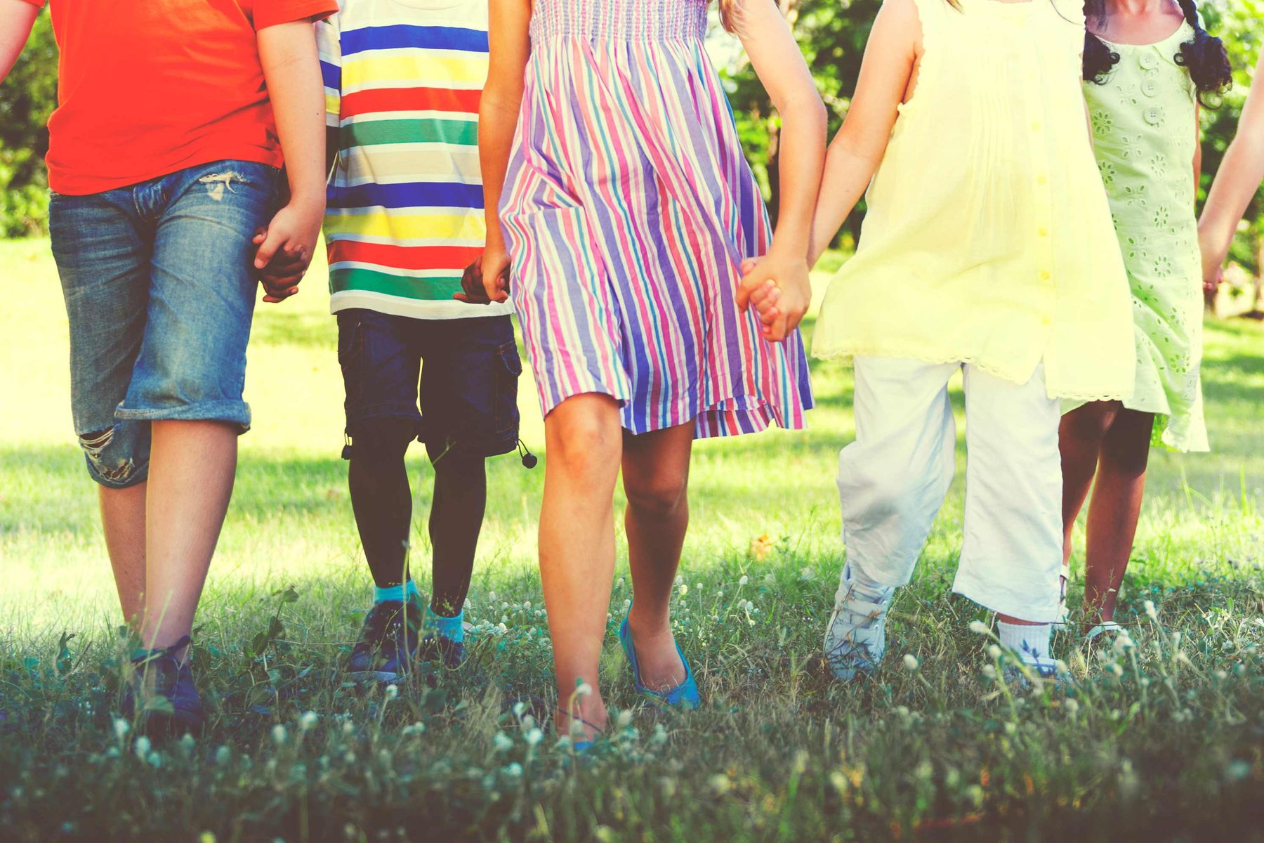 Children in a field holding hands