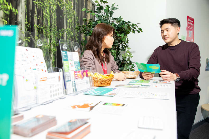 Student at an event, talking to member of staff