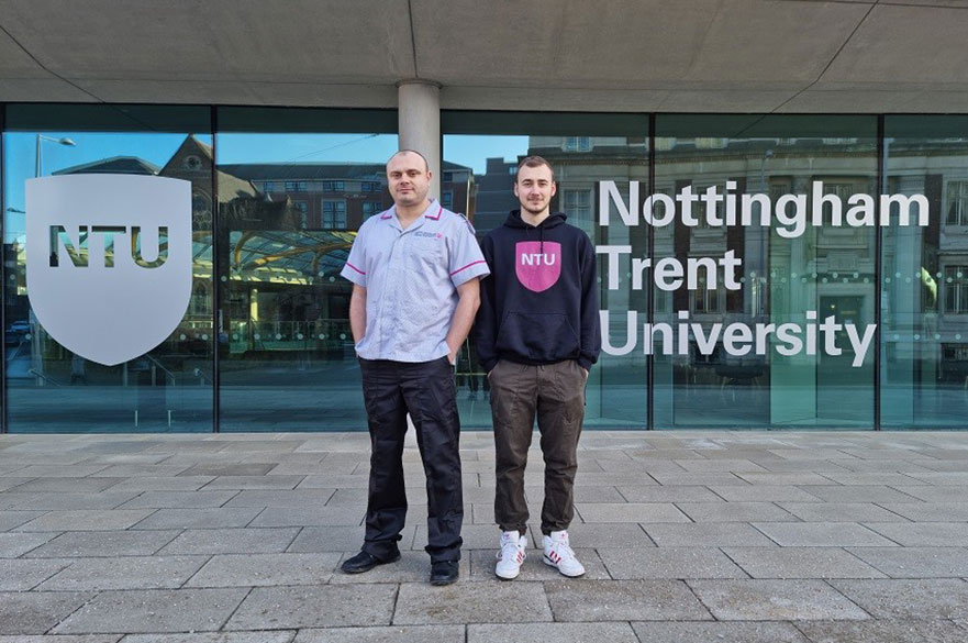 Father and son standing outside Newton building