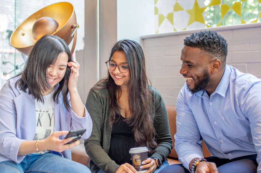 Students chatting and looking at phone in a café
