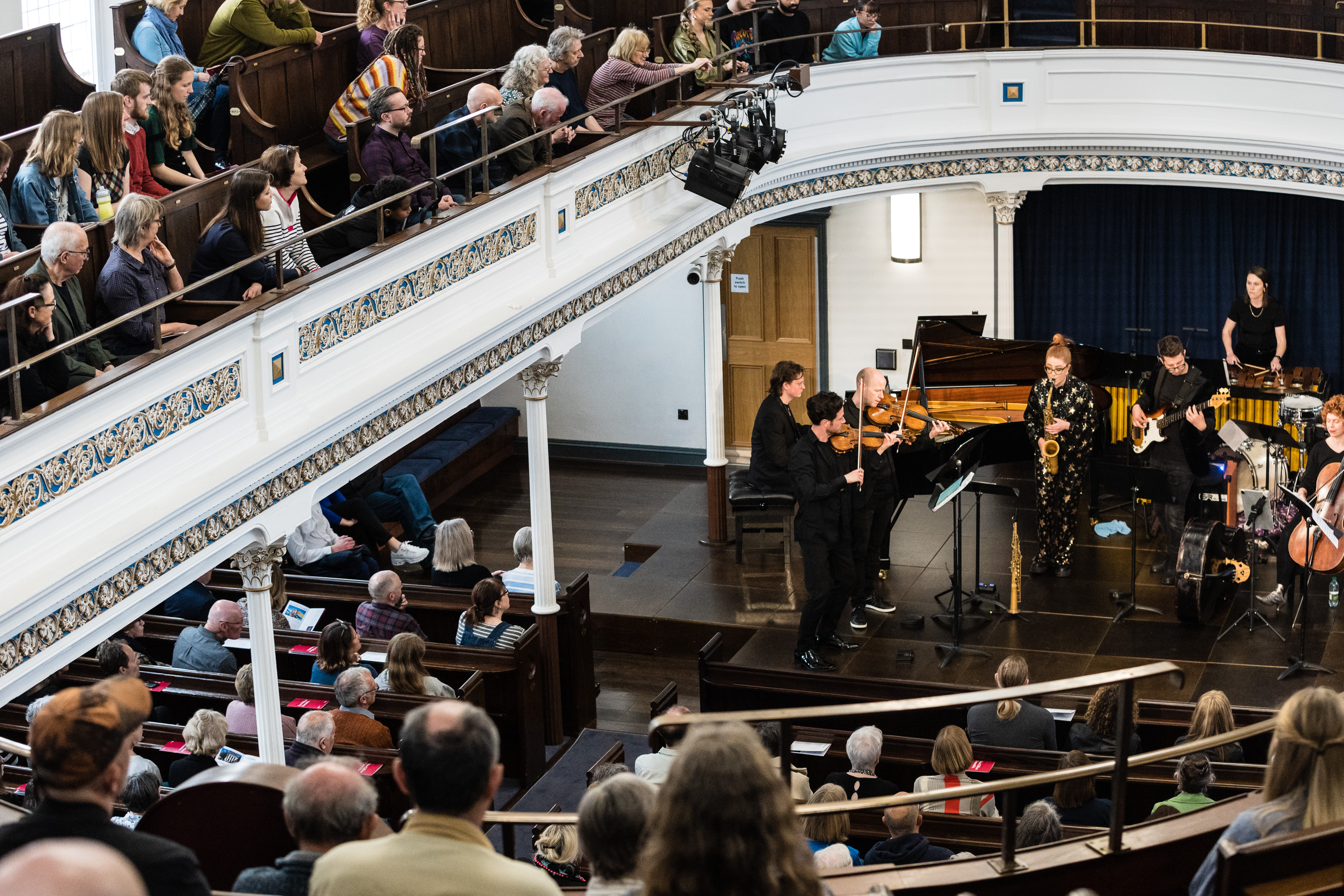 A band on stage performing a concert in University Hall