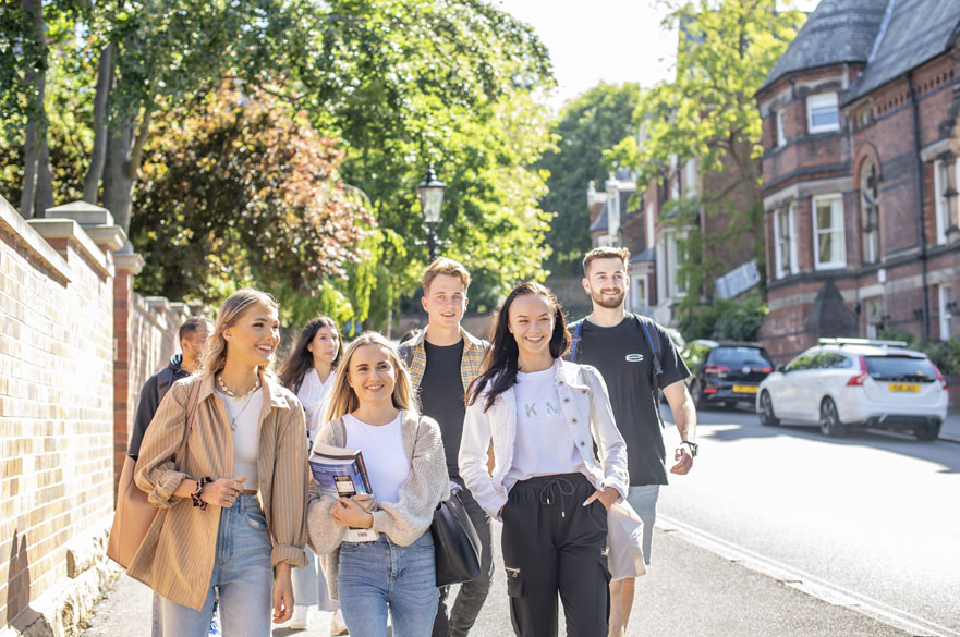 A group of seven students walking down a road together